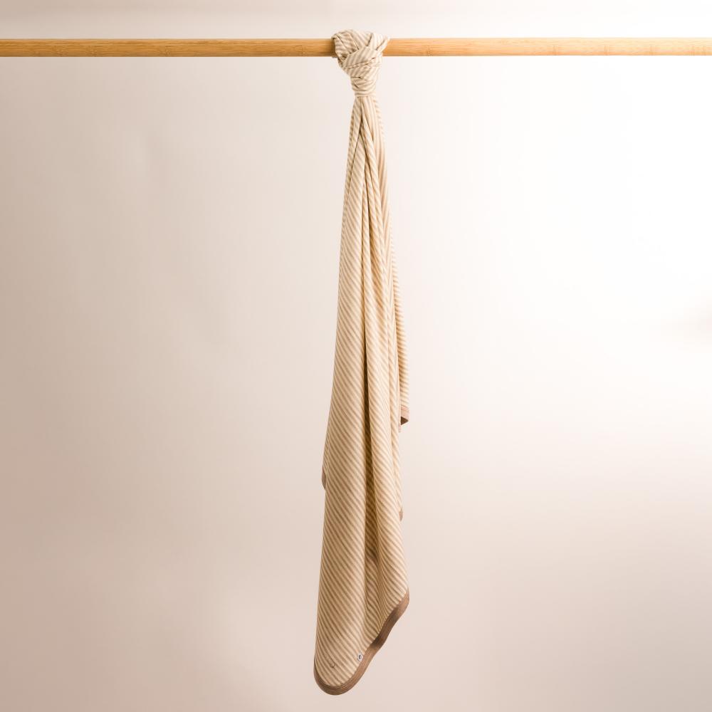 The sleep store merino jersey blanket swaddle hanging on rail