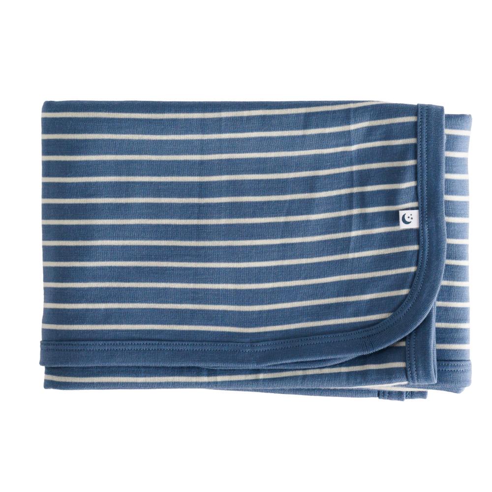 A folded baby blanket made from jersey merino with horizontal blue and off-white stripes, featuring a small white logo tag on the right side, set against a plain white background.