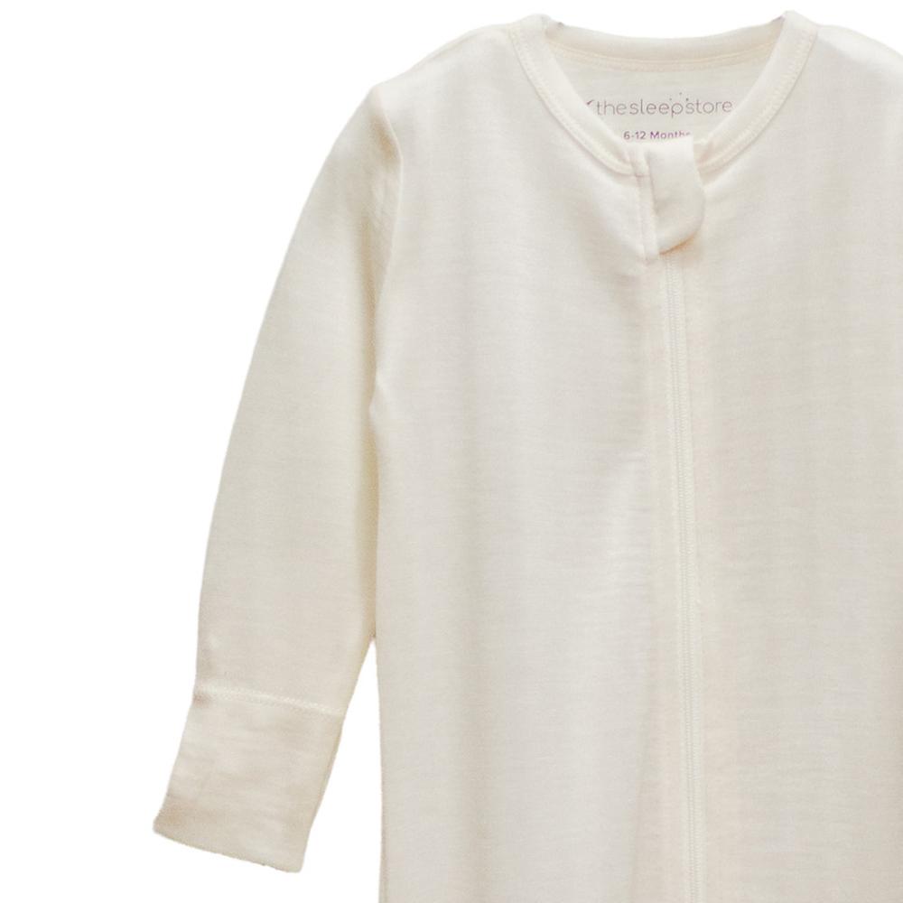 The sleep store white merino  baby onesie with a zipper on a white background