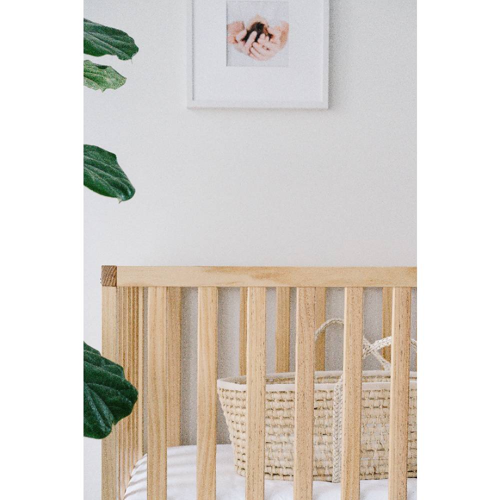 Wooden cot with moses basket inside