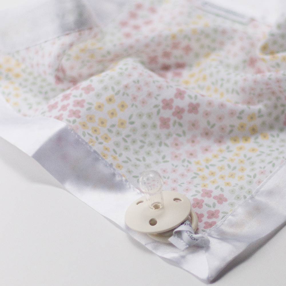 Pacifier attached to cotton muslin comforter