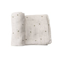 Muslin swaddling wrap with small bee patterns on a white background