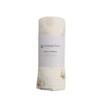 Muslin swaddle blanket with 'thesleepstore' label on a white background