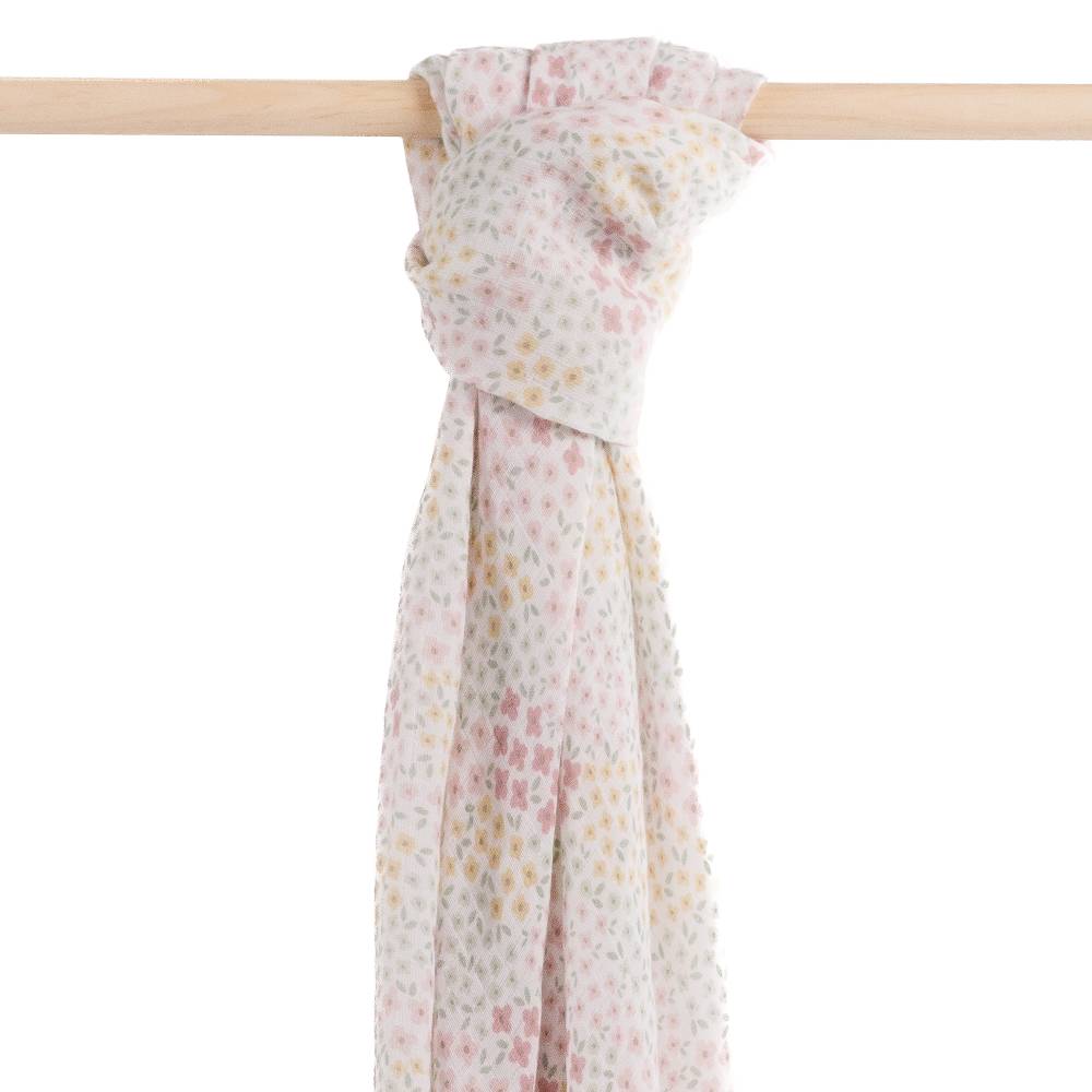 Floral muslin swaddle tied on a wooden rod against a white background