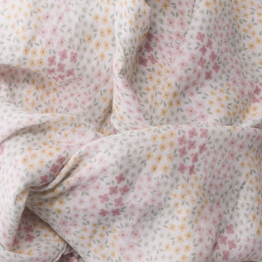 Floral patterned muslin wrap with small flowers in pink, yellow, and green on a light background.