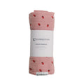 Pink muslin swaddle with berry pattern on a white background