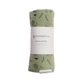 Green swaddle blanket with animal prints and 'The Sleep Store' label on a white background