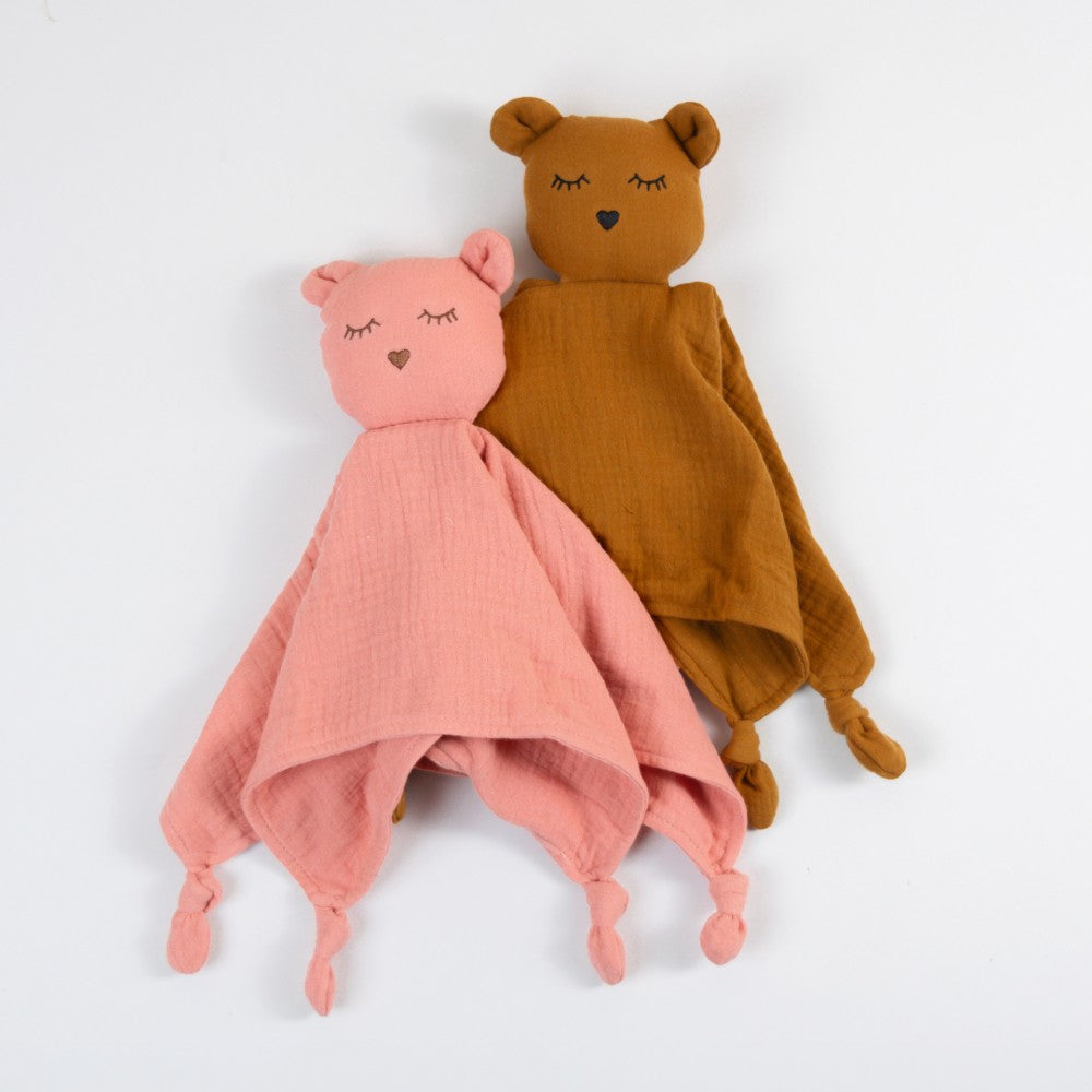 Two cotton muslin soft cotton muslin comforters, one pink and one brown, on a white background