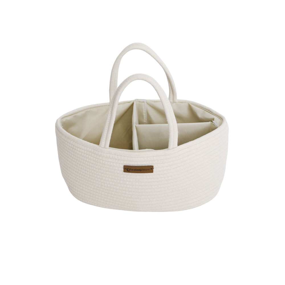 An off-white woven basket organizer with dual top handles, a divided interior, and a small brown leather brand patch on the front, shown on a plain white background.