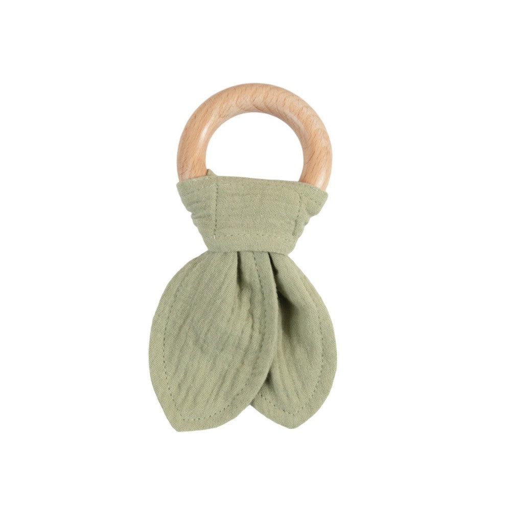 Teething ring with wooden handle and green muslin cotton fabric on a white background