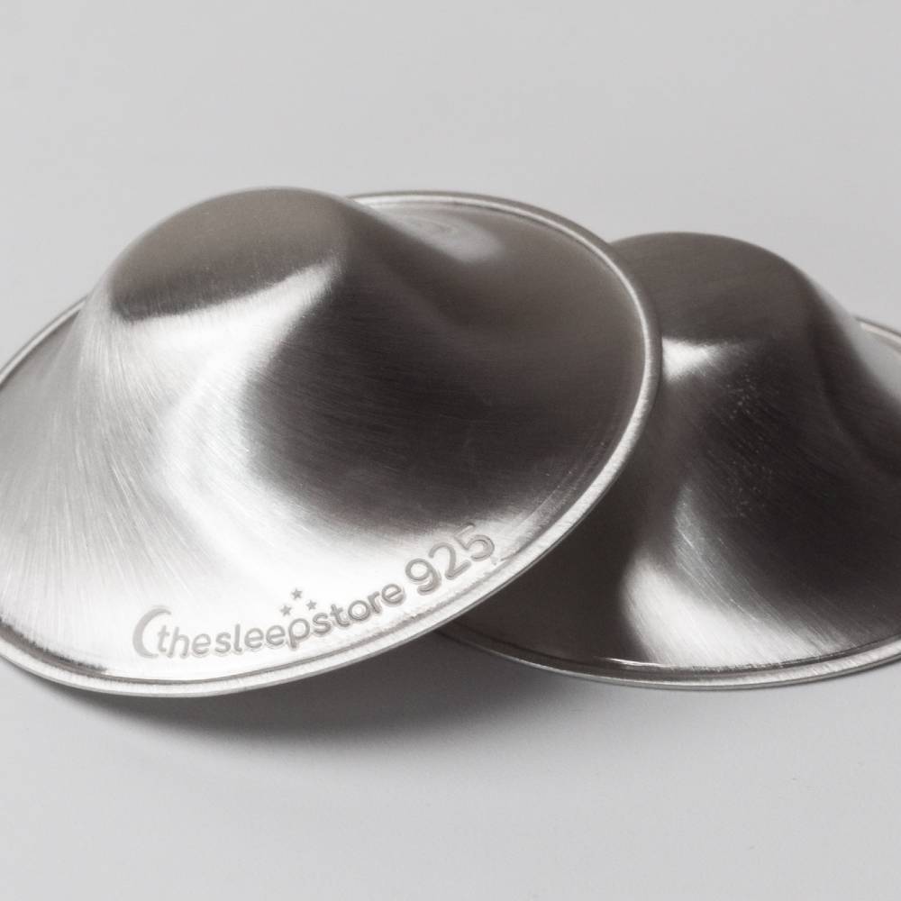 Two silver metal nipple cups with 'thesleepstore 925' branding on a light gray background