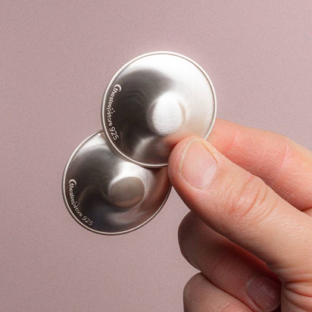 silver nipple cups on a pink background