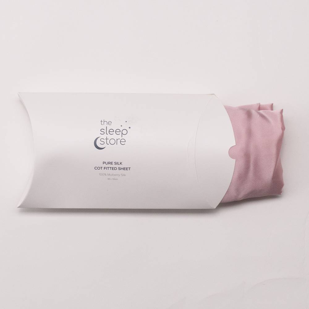 Pink fitted sheet on a white pillow with 'The Sleep Store' branding.