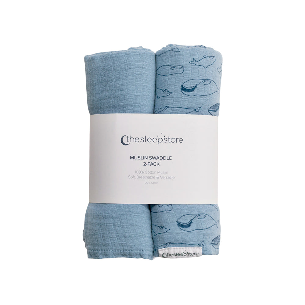 Two blue muslin swaddles with whale pattern packaging on a white background