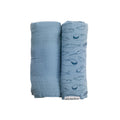 Two blue swaddle blankets, one plain and one with whale pattern, on a white background.