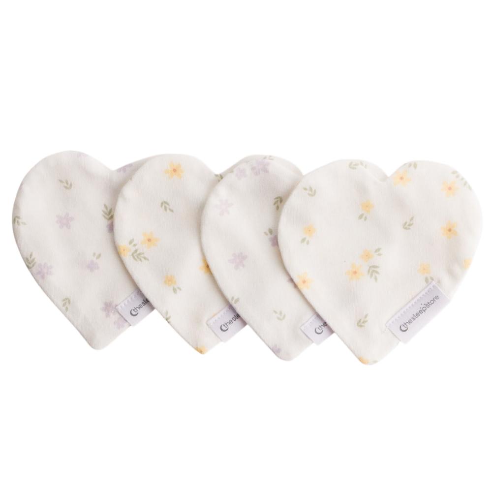 Four heart-shaped comforters with floral patterns on a white background