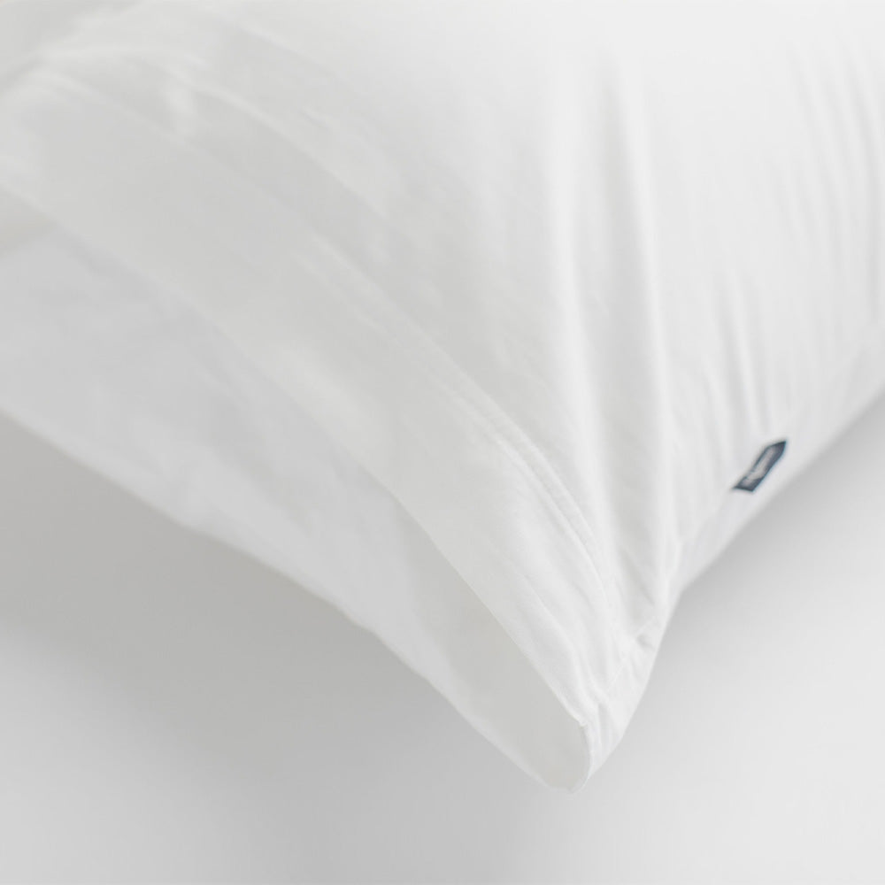 Close-up of a white pillow with a brand logo on a white background