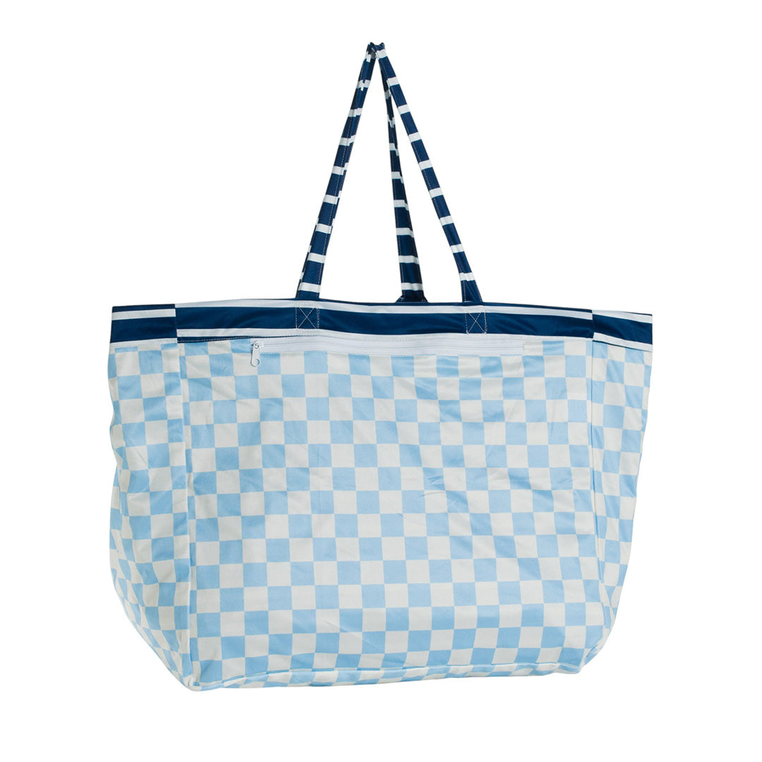 Blue and white checkered reverse design on the Nestling tote style beach bag with striped handles on a white background