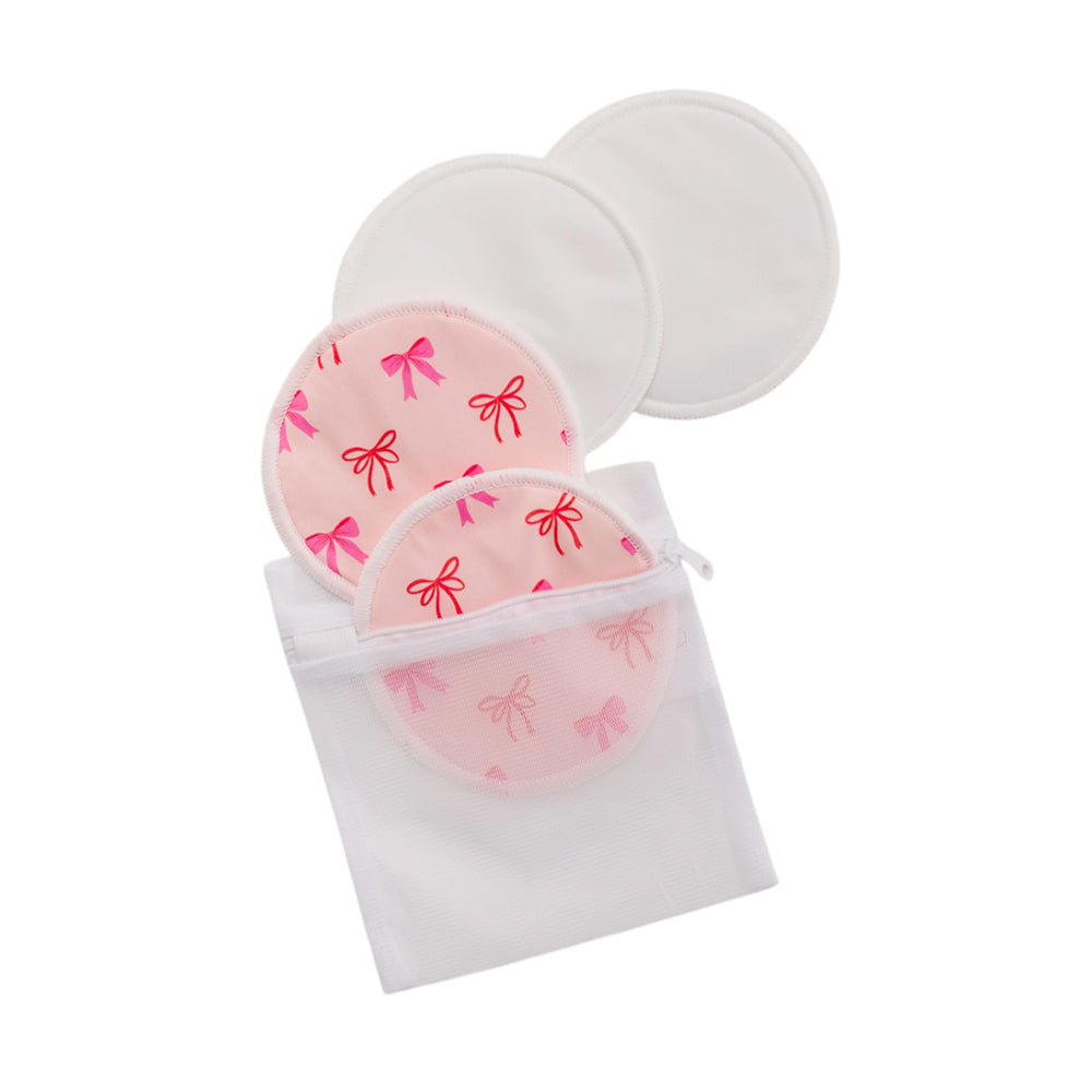 2 pairs of bamboo reusable breast pads with pink bow pattern in wash bag on a white background