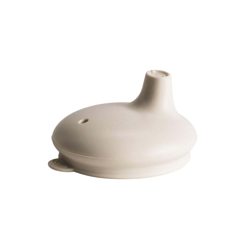 Nestling silicone sippy cup lid in oat colour on a white background