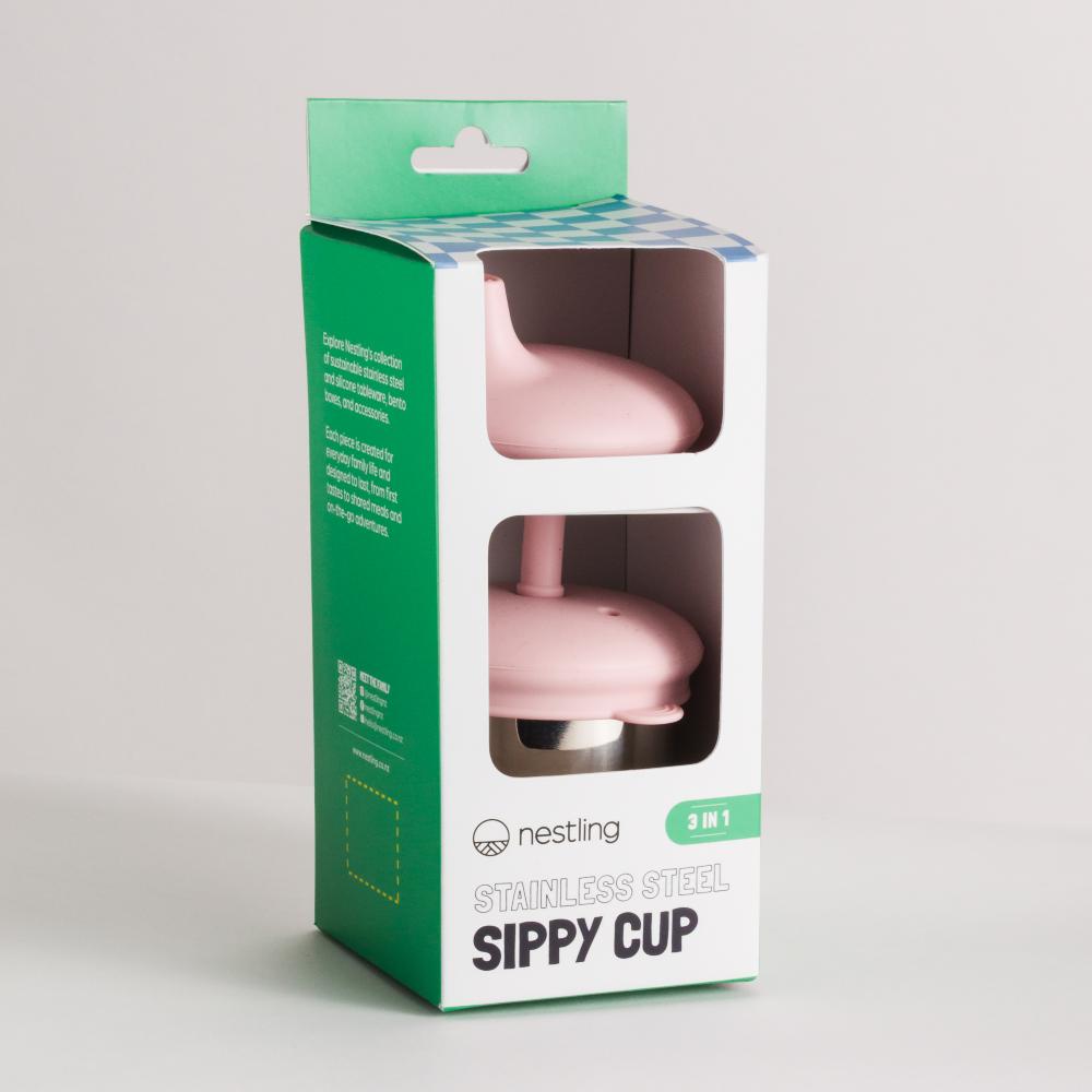 Pink sippy cup lids in a green and white Nestling packaging box on a light gray background