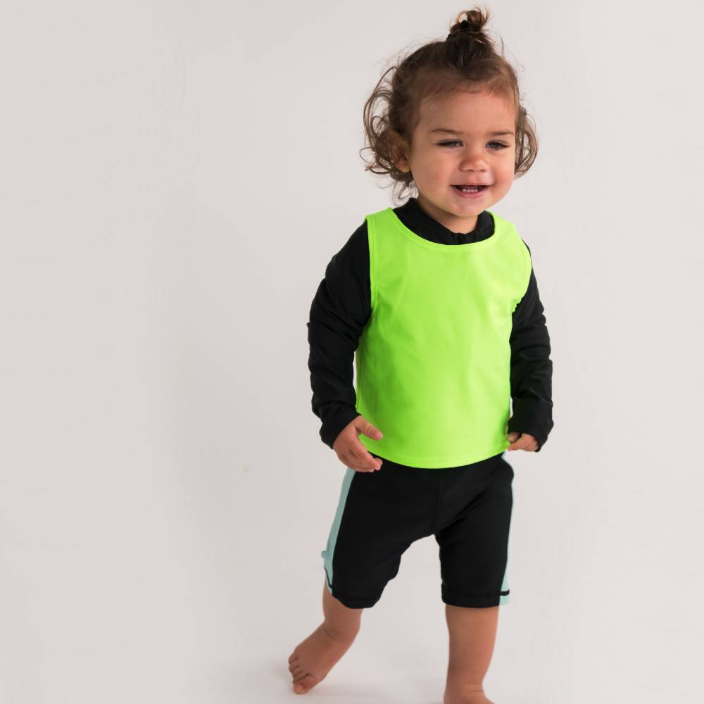 Child wearing a bright green swim vest on a white background