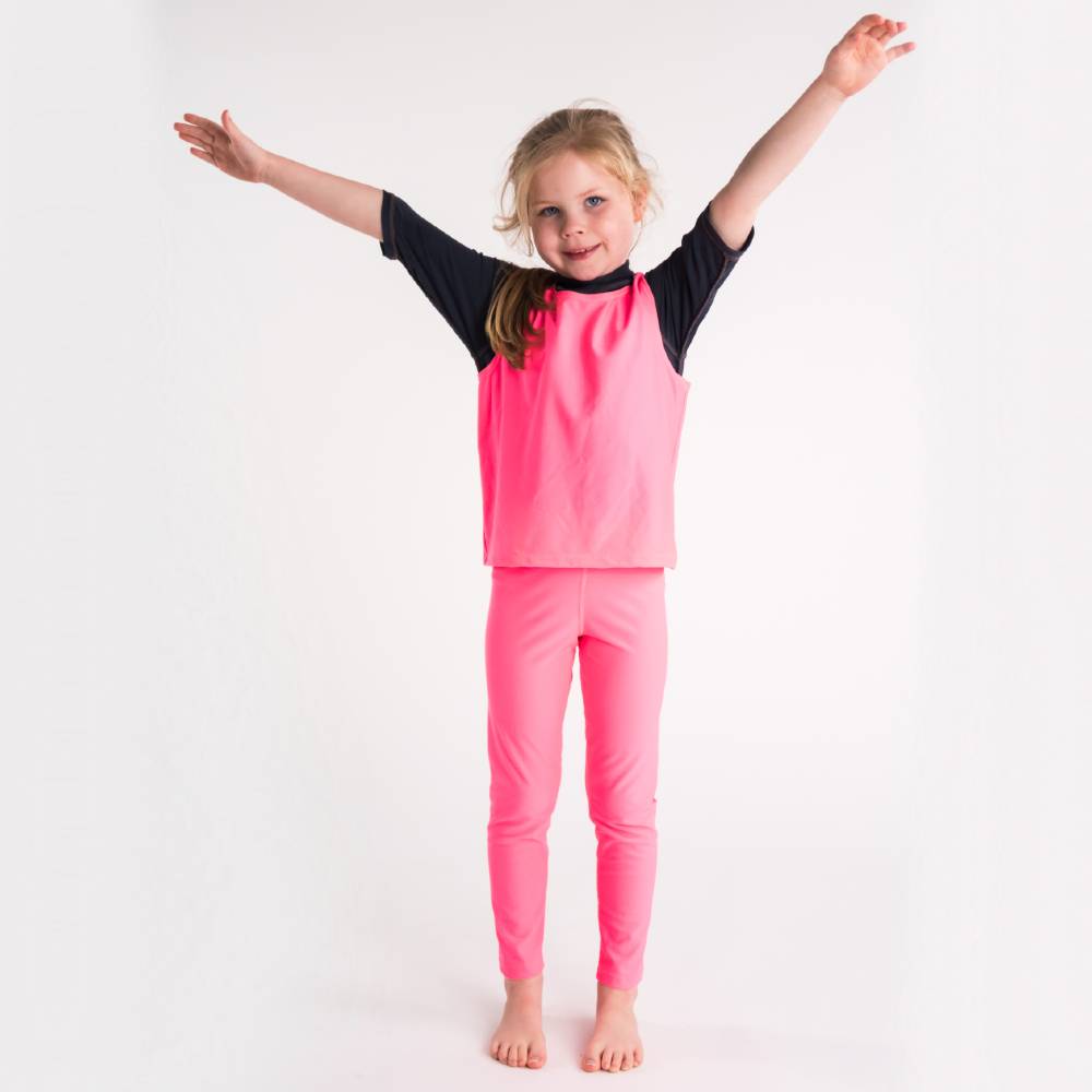 Child wearing a pink swim vest with arms raised on a white background