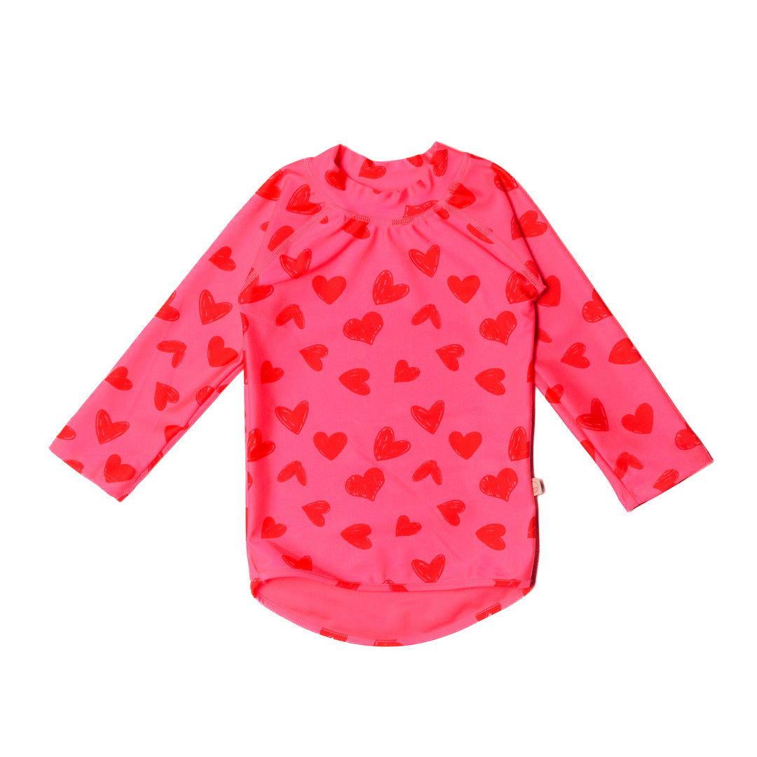 Pink long-sleeve swim rash vest with red heart patterns on a white background