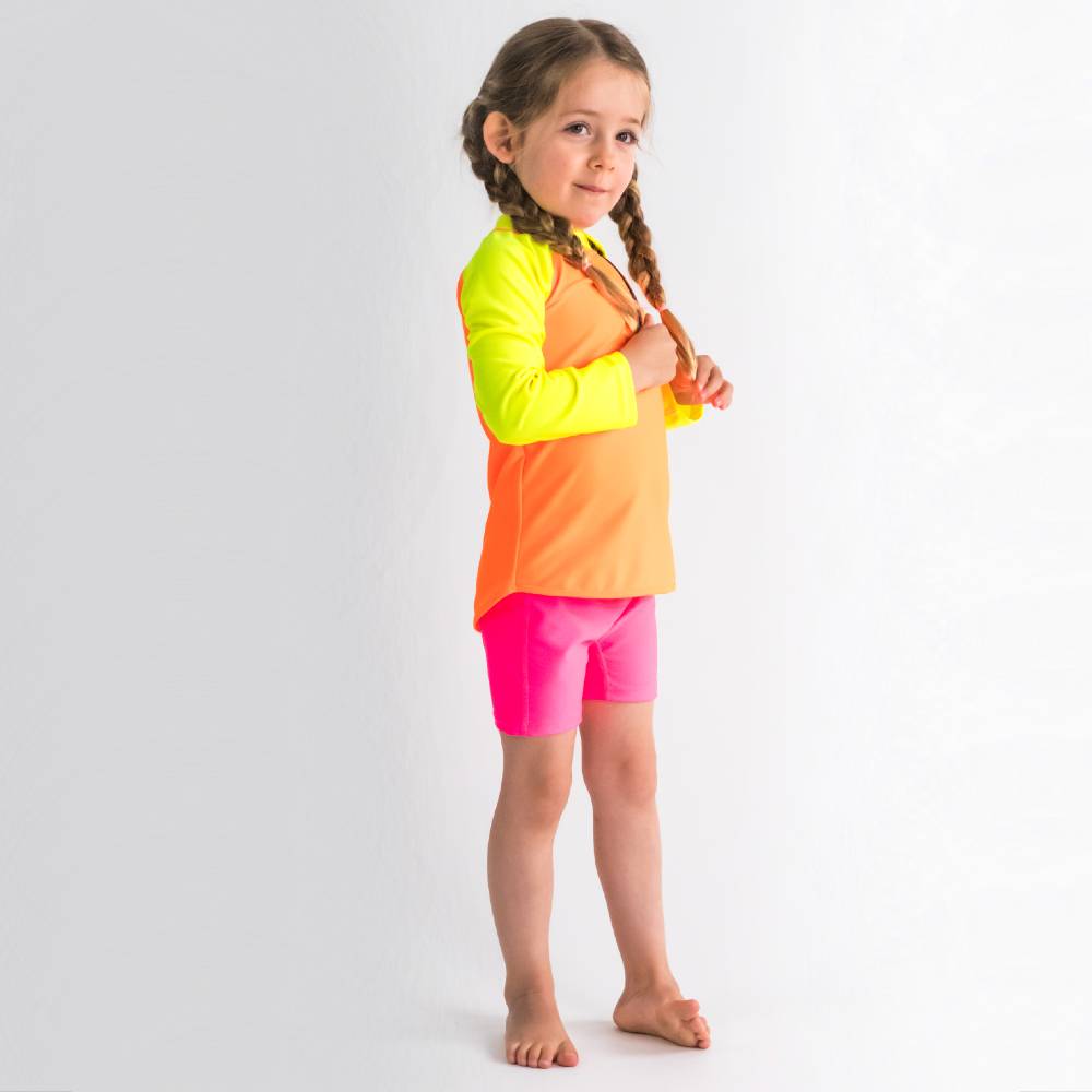 Young girl wearing a colorful two-piece swimsuit on a white background