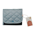 Quilted sage green folded nestling change mat with a tag on a white background
