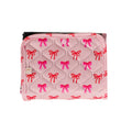 Pink quilted travel change mat with red and pink bow patterns on a white background
