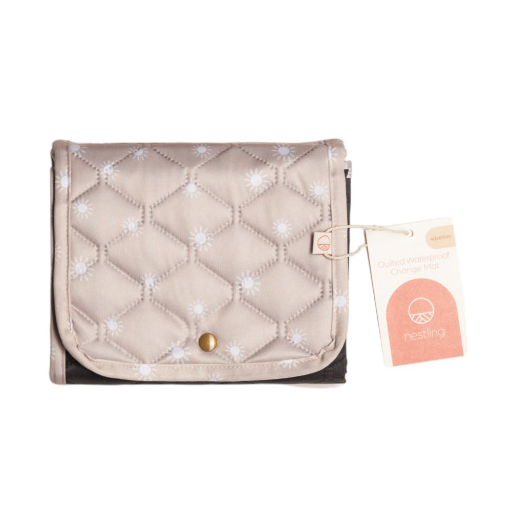 Quilted beige waterproof baby change mat with a gold button and a visible nestling brand tag on a white background
