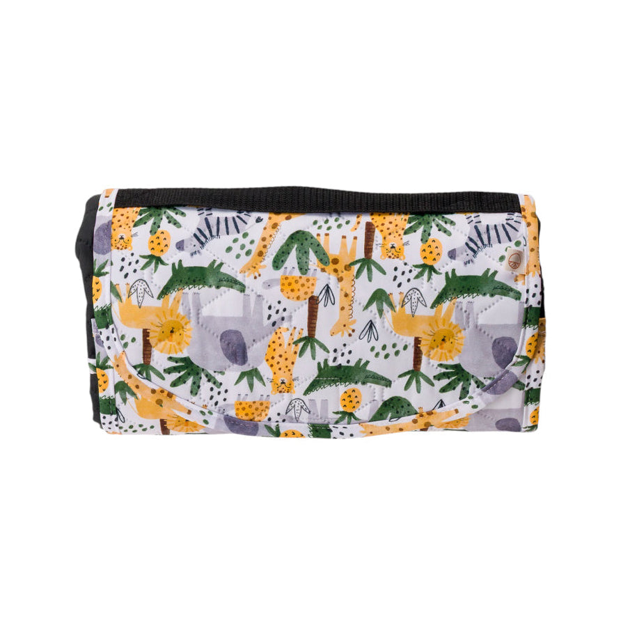 A folded kids play mat with a flap closure, featuring a playful safari print of yellow giraffes, green palm trees, and purple foliage on a white background.