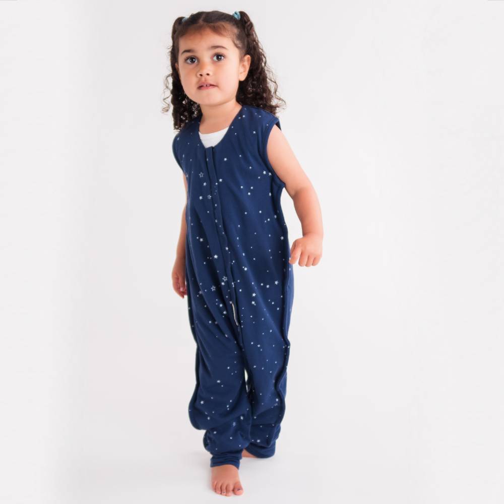 Child wearing a navy blue onesie with star pattern on a white background