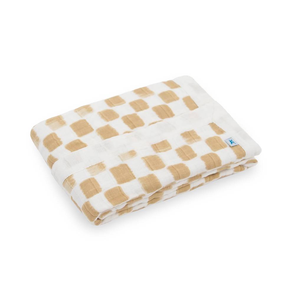 Folded white and beige organic cotton muslin blanket with a little unicorn brand logo on a white background