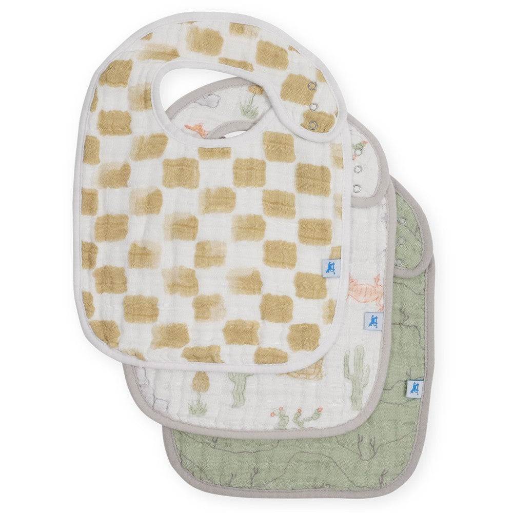 Set of three cotton muslin baby bibs with beige and white checkered, white and green desert prints on a white background