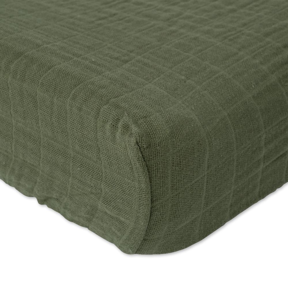 Little unicorn cotton muslin changing pad cover in a fern green colour on a bed with white background