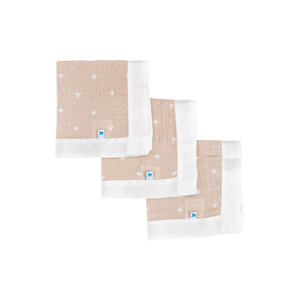 Three set of beige and white patterned cloths with white satin trim on a white background