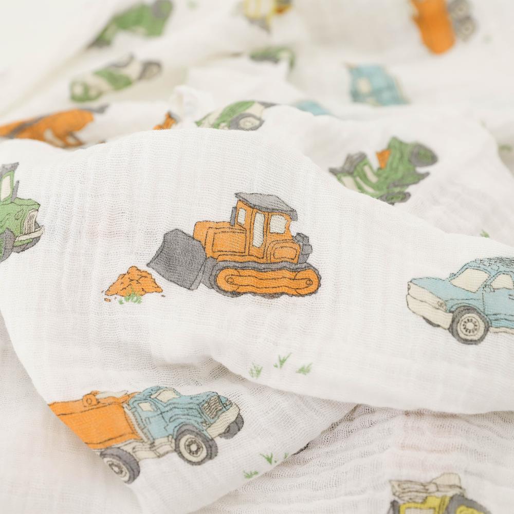 Close-up of a white cotton muslin Baby blanket with construction vehicle pattern