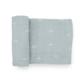 A light blue cotton muslin swaddle blanket with white rainbow patterns on a white background
