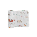 A white cotton muslin swaddle blanket with farmyard theme patterns on a white background