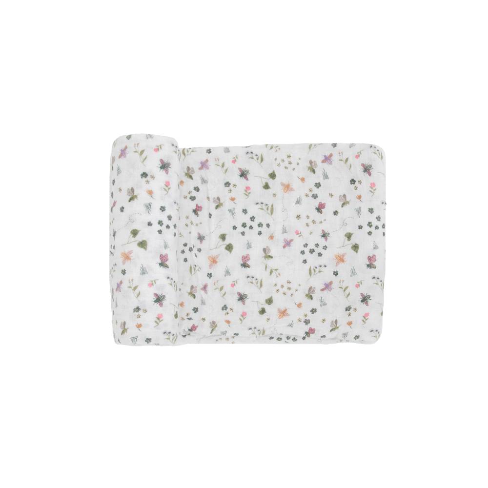 A white cotton muslin swaddle blanket with garden, butterfly theme on a white background