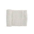 White and beige gingham muslin swaddle blanket on a white background