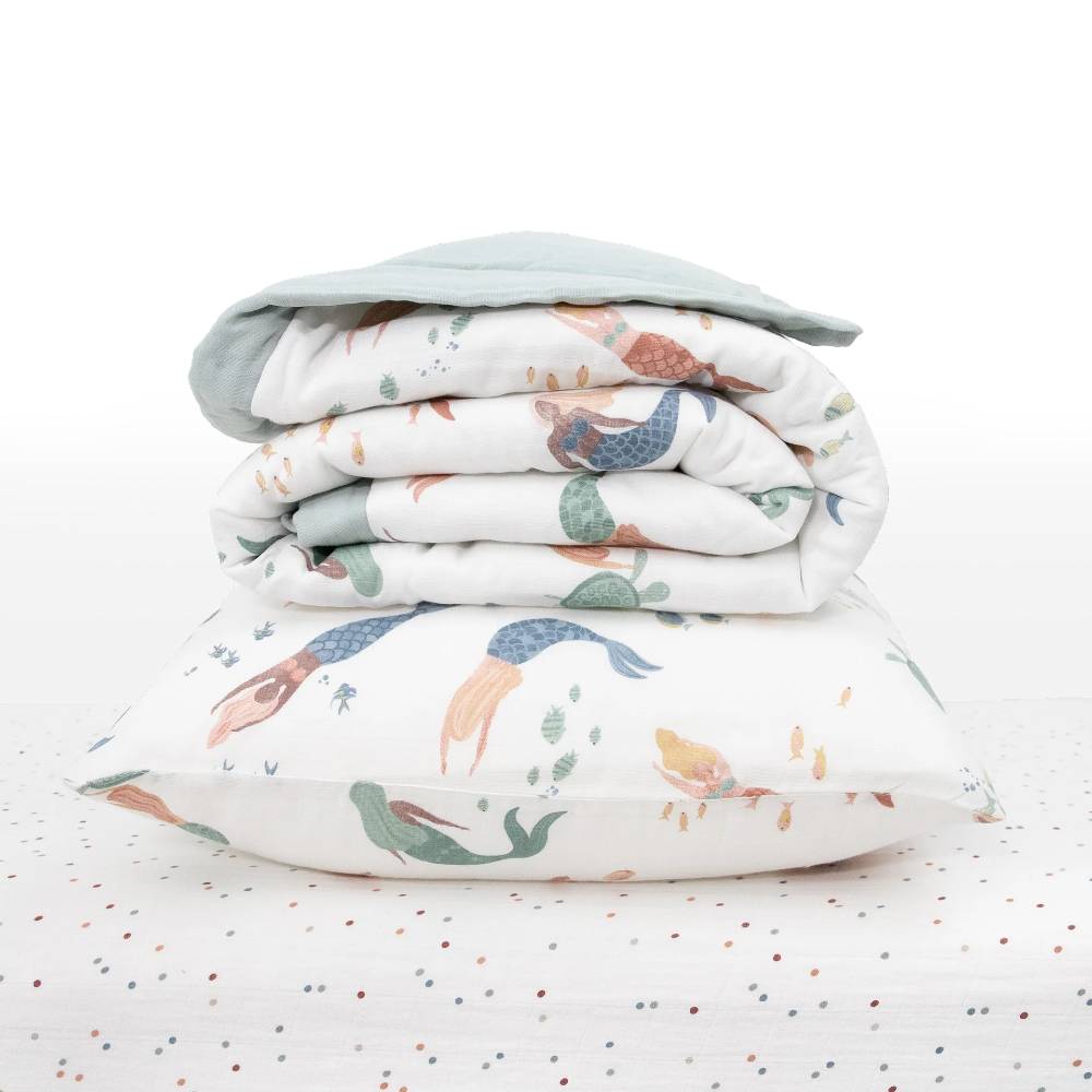 White Stack including baby blanket and pillow with colourful mermaid patterns and dotted sheet on a white background
