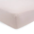 Soft dusky pink fitted sheet on a bed with white background 