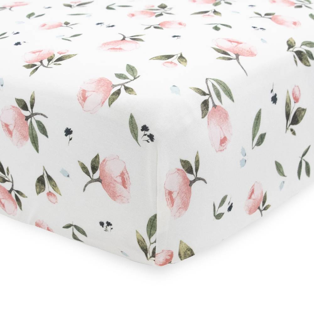 White floral patterned fitted sheet with pink flowers and green leaves on a white background