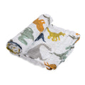 A white cotton muslin swaddle with colourful dino print on a white background