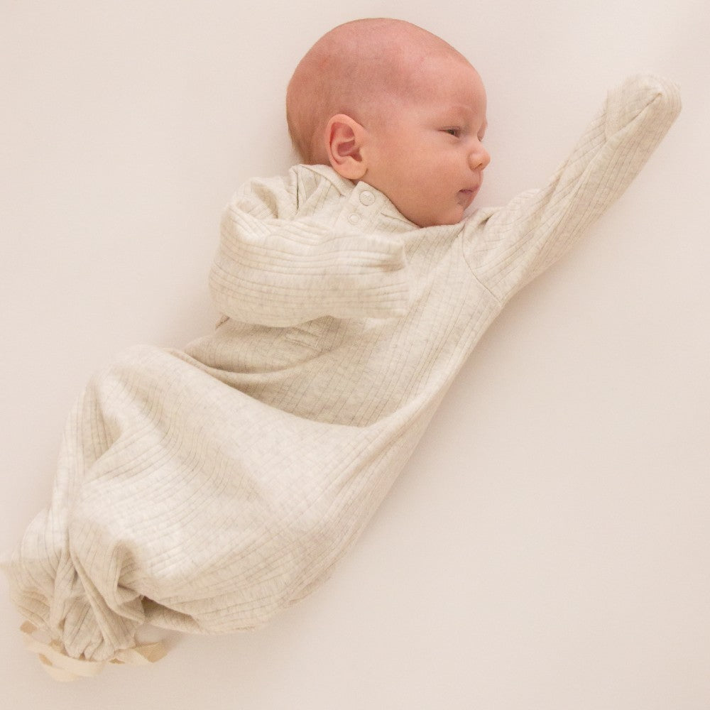 Newborn baby dredd in a cream rib merino baby gown with drawstring bottom and foldover newborn mitten sleeves