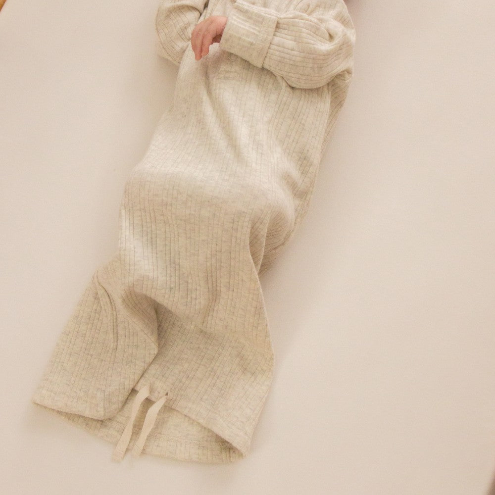 Beige ribbedbaby gown on a light beige background