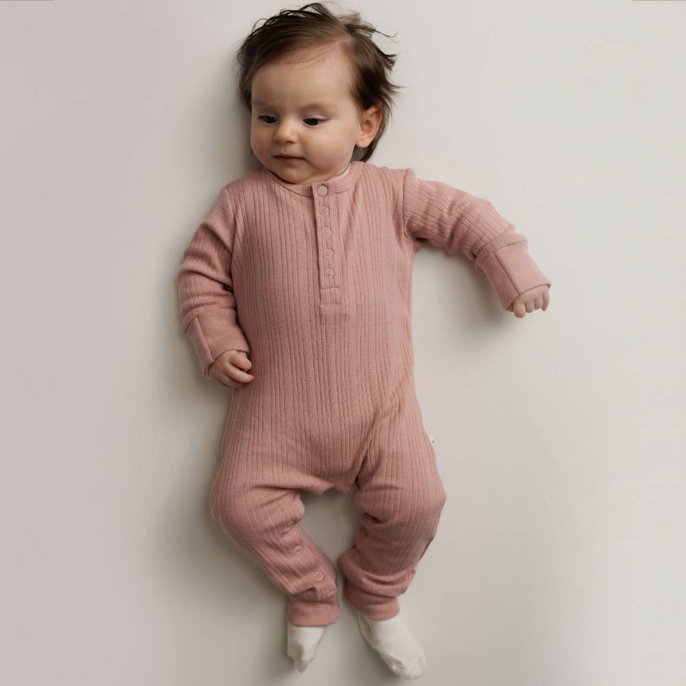 Baby wearing a Dusk Marl Woolbabe Merino Rib Henley Suit. 